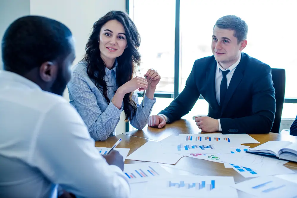 Diverse group of business professionals discussing documents at a meeting table